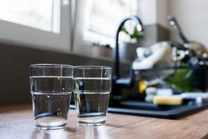 Two glasses of drinking water placed on near the kitchen tap
