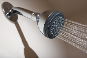 Shower head in bathroom spraying stream of water