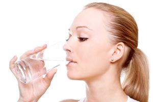 A woman drinking water from a glass.